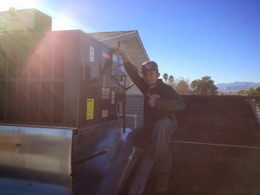HVAC technician performing AC Tune-Up on a rooftop unit in Reynoldsburg